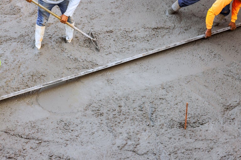 Workers applying finishing techniques to fresh concrete