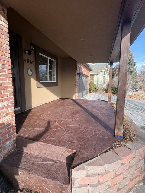Covered porch with stained concrete floor and red brick walls at house number 4860